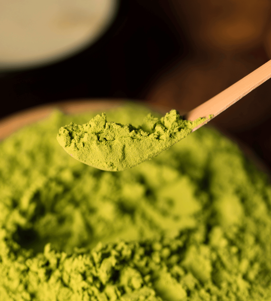 Kratom Pulver in einer Schüssel auf einem Holzlöffel